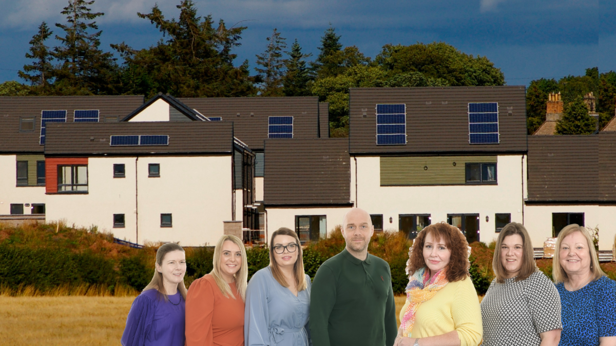 Picture of 8 BHA neighbourhood managers standing in a row in front of BHA homes
